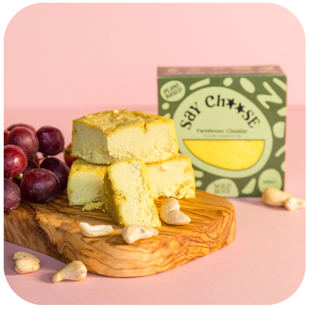 Farmhouse Mature Cheese with grapes on the chopping board 