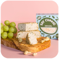 Garlic & Chive Cultured Cashew Cheese with grapes on the chopping board 