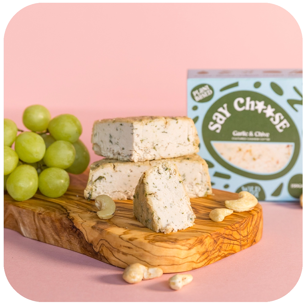 Garlic & Chive Cultured Cashew Cheese with grapes on the chopping board 