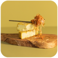 Farmhouse Mature Cheese and Kimchi on the serving board close up with a spoon 