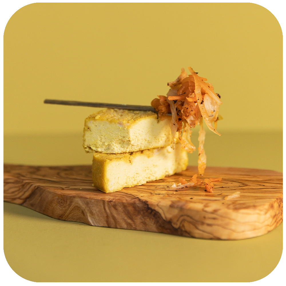 Farmhouse Mature Cheese and Kimchi on the serving board close up with a spoon 